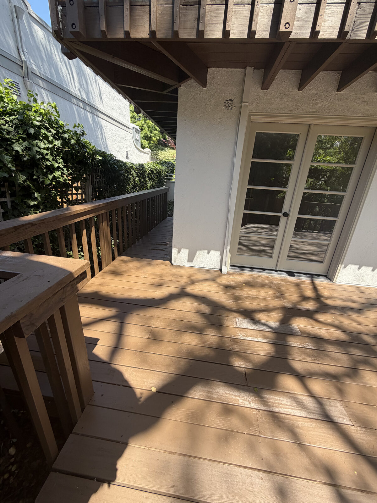 Wooden backyard deck with railing and French doors